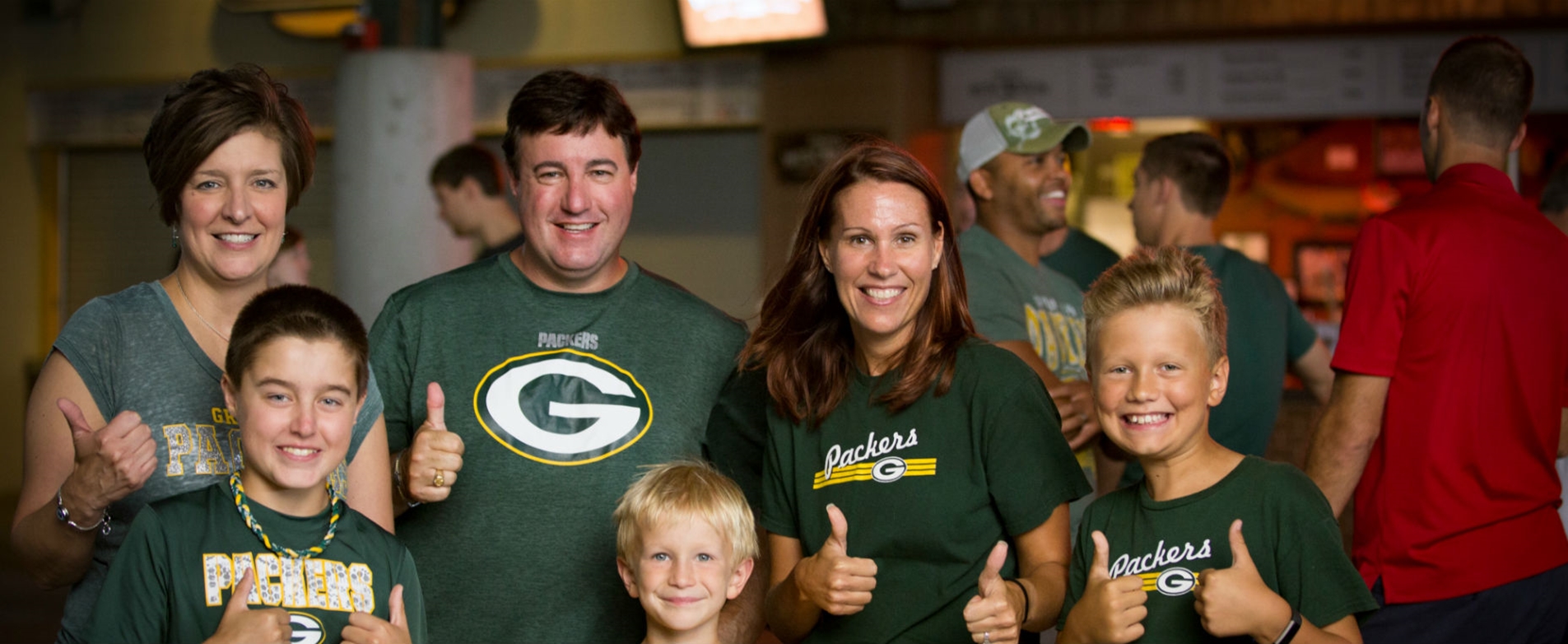 Green Bay Packers fans wearing team colours and cheesehead hat at