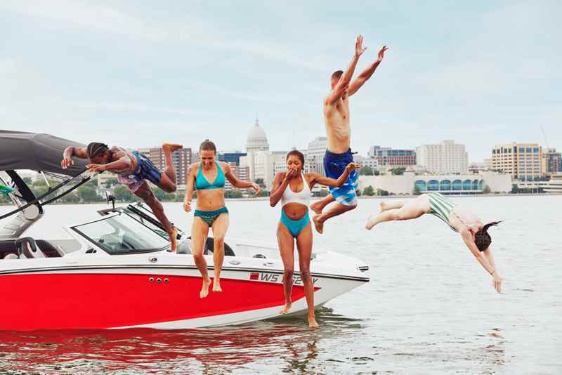 friends jump off a boat into lake monona in madison